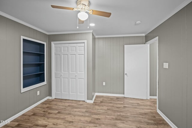 unfurnished bedroom with a closet, light hardwood / wood-style flooring, ceiling fan, and crown molding