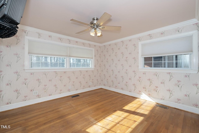 empty room featuring ceiling fan, hardwood / wood-style floors, and ornamental molding