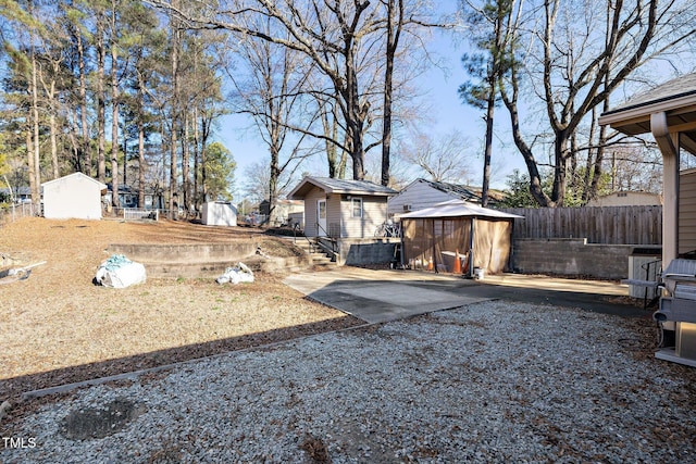 view of yard featuring a storage unit and a patio area