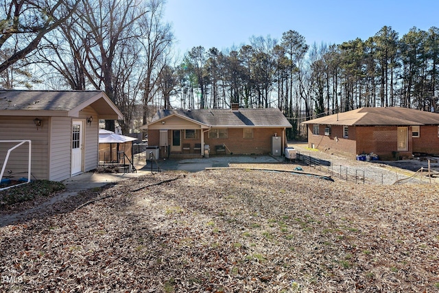 back of property featuring an outbuilding and a patio