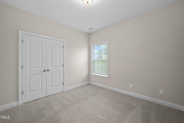 unfurnished bedroom featuring carpet flooring and a closet