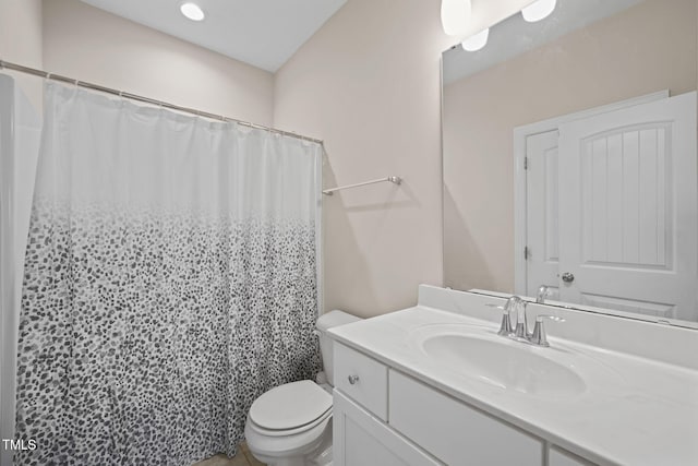 bathroom with walk in shower, vanity, and toilet