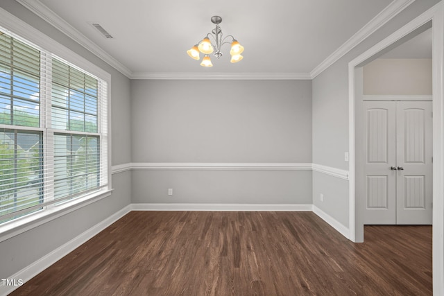 empty room with ornamental molding, dark wood-type flooring, and a notable chandelier