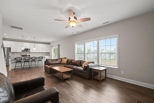 living room with ceiling fan and dark wood-type flooring