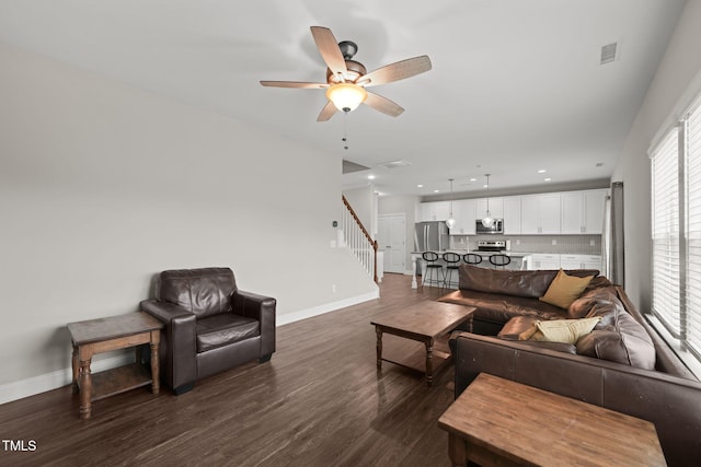 living room with ceiling fan and dark wood-type flooring