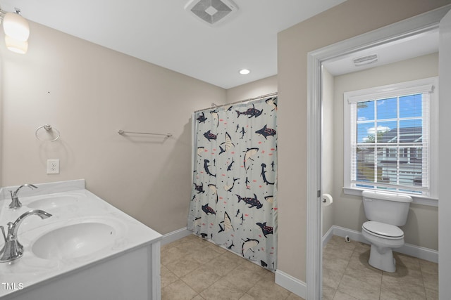 bathroom with tile patterned floors, vanity, toilet, and walk in shower