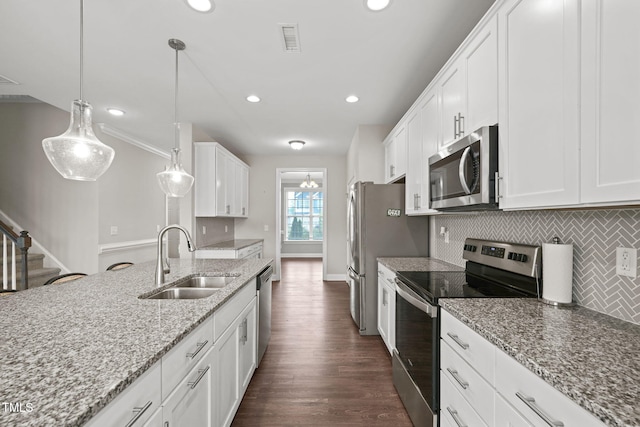 kitchen featuring white cabinets, appliances with stainless steel finishes, pendant lighting, and sink