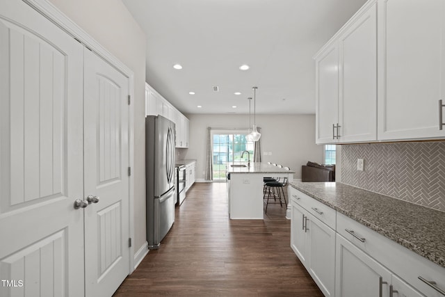 kitchen featuring white cabinets, light stone countertops, dark wood-type flooring, and appliances with stainless steel finishes