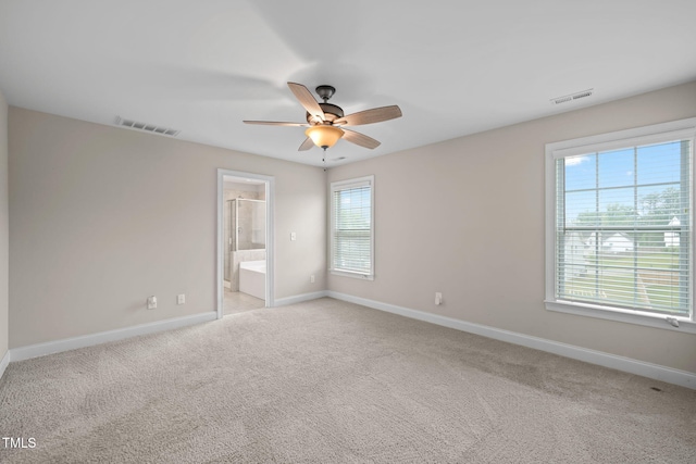 unfurnished bedroom featuring light carpet, ensuite bath, and ceiling fan