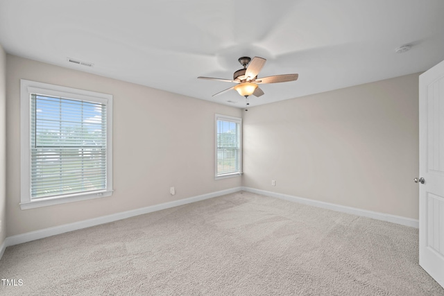 carpeted spare room with plenty of natural light and ceiling fan