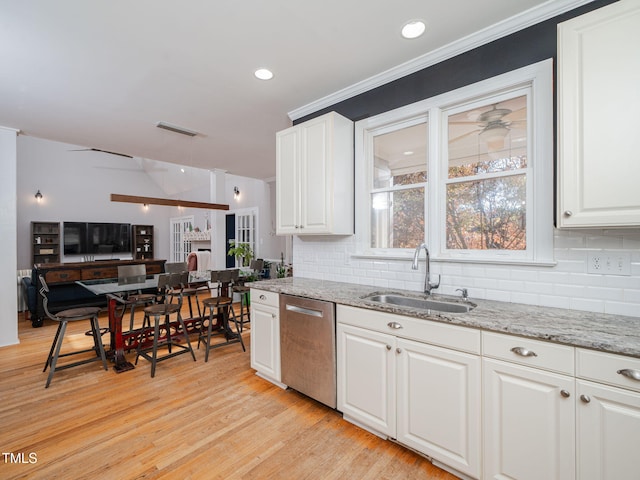 kitchen featuring light wood finished floors, visible vents, stainless steel dishwasher, white cabinetry, and a sink