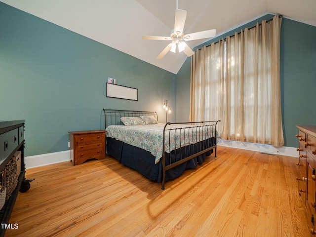 bedroom featuring a ceiling fan, vaulted ceiling, baseboards, and wood finished floors