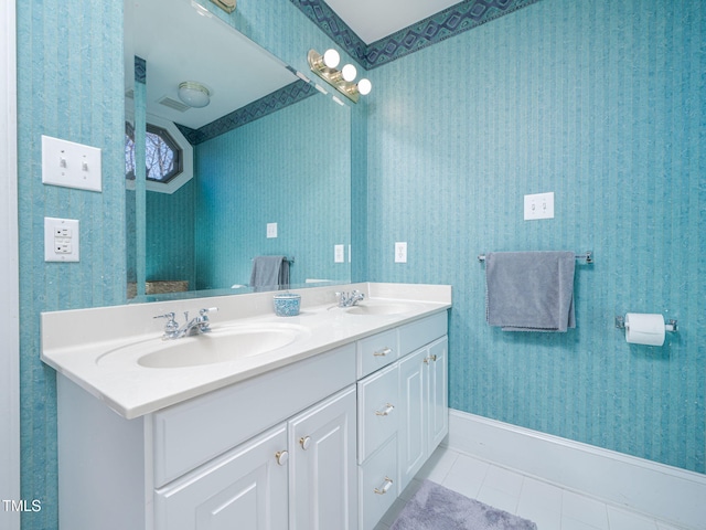 full bathroom featuring tile patterned flooring, double vanity, a sink, and wallpapered walls