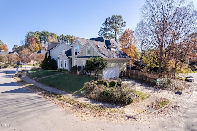 view of home's exterior with driveway, a lawn, an attached garage, fence, and board and batten siding