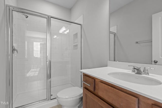 bathroom with vanity, toilet, and a shower with door