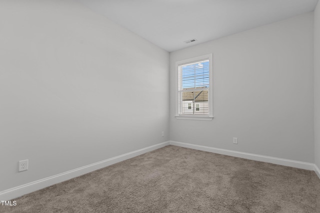 empty room featuring carpet and vaulted ceiling