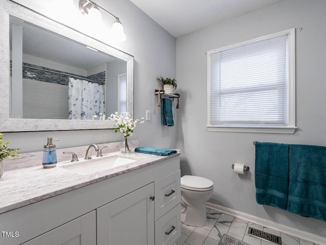 bathroom with vanity, curtained shower, and toilet