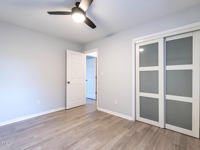 unfurnished bedroom featuring ceiling fan, light hardwood / wood-style floors, and a closet