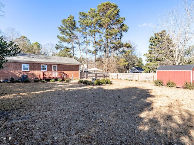 view of yard with a wooden deck, a storage shed, and central air condition unit