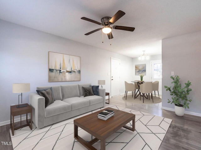 living room with hardwood / wood-style flooring, ceiling fan with notable chandelier, and a textured ceiling