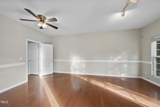 empty room with ceiling fan, dark hardwood / wood-style flooring, and a textured ceiling