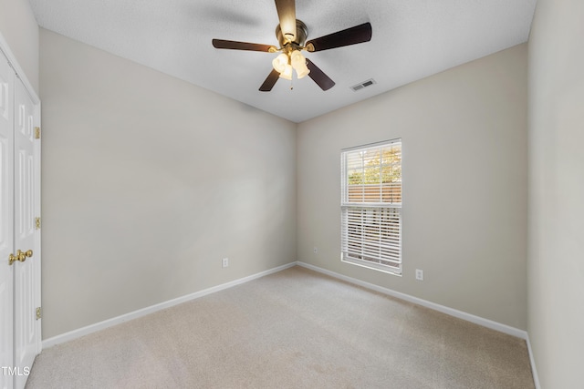 carpeted empty room featuring ceiling fan and a textured ceiling