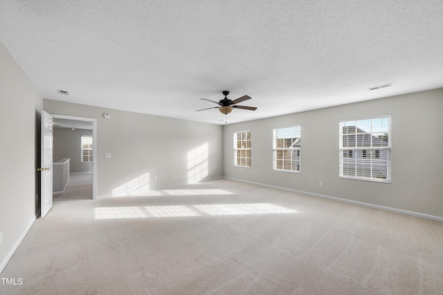 carpeted empty room with ceiling fan and a textured ceiling