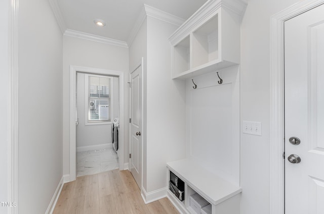 mudroom featuring washer / clothes dryer, ornamental molding, and light wood-type flooring