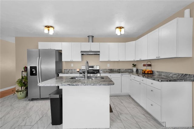 kitchen featuring sink, dark stone countertops, an island with sink, white cabinets, and appliances with stainless steel finishes