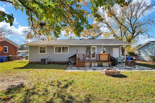 rear view of property featuring a lawn, a deck, an outdoor fire pit, cooling unit, and a patio