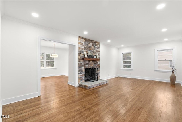 303 Forest Rd, Oxford, NC 27565 - unfurnished living room featuring a stone fireplace, crown molding, wood finished floors, and recessed lighting
