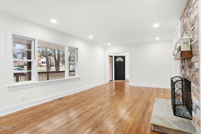 303 Forest Rd, Oxford, NC 27565 - unfurnished living room featuring crown molding, light wood-style floors, a stone fireplace, and recessed lighting