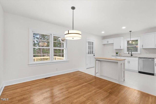 303 Forest Rd, Oxford, NC 27565 - kitchen with dishwasher, light countertops, tasteful backsplash, white cabinetry, and healthy amount of natural light