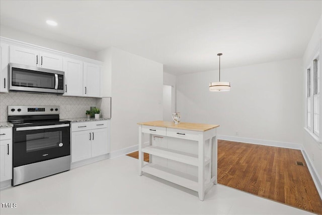 303 Forest Rd, Oxford, NC 27565 - kitchen featuring appliances with stainless steel finishes, backsplash, white cabinetry, hanging light fixtures, and light stone countertops