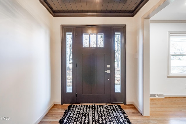 foyer entrance with light hardwood / wood-style flooring, plenty of natural light, and ornamental molding