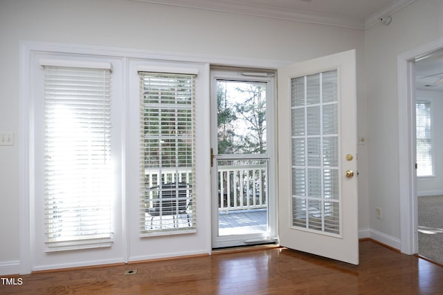 doorway featuring crown molding, ceiling fan, and dark hardwood / wood-style floors