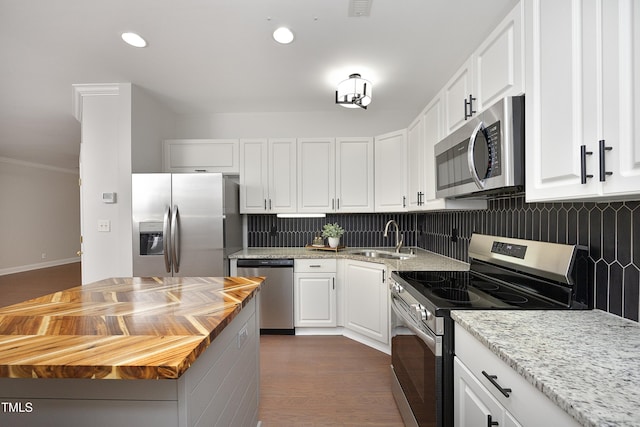 kitchen with white cabinets, backsplash, stainless steel appliances, and sink