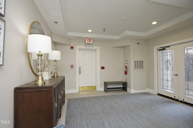 entrance foyer featuring french doors, a raised ceiling, and ornamental molding