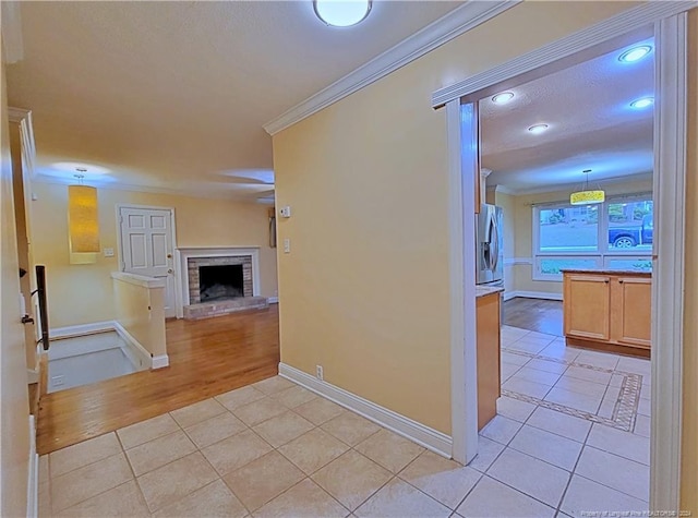 hallway with light hardwood / wood-style floors and ornamental molding