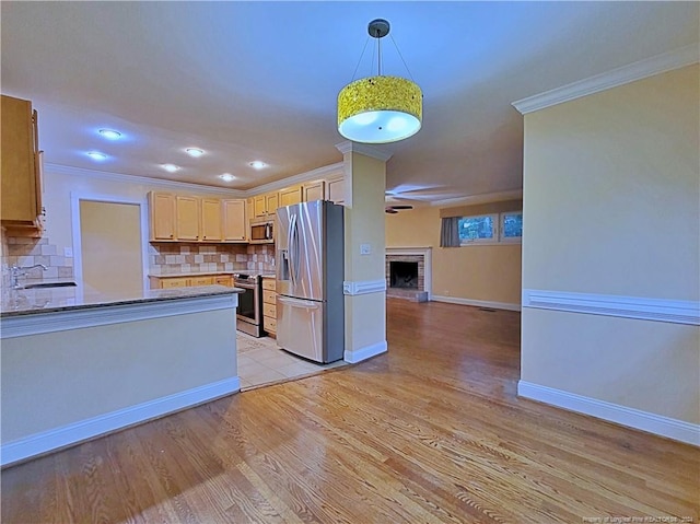 kitchen featuring light brown cabinets, a brick fireplace, decorative backsplash, light hardwood / wood-style floors, and stainless steel appliances