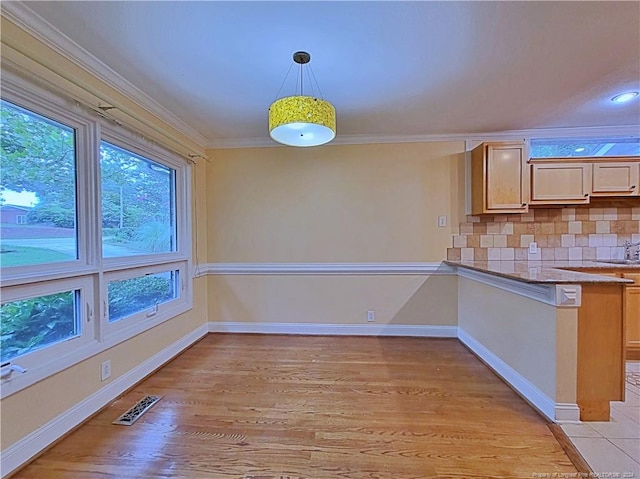 unfurnished dining area with light hardwood / wood-style floors, sink, and crown molding