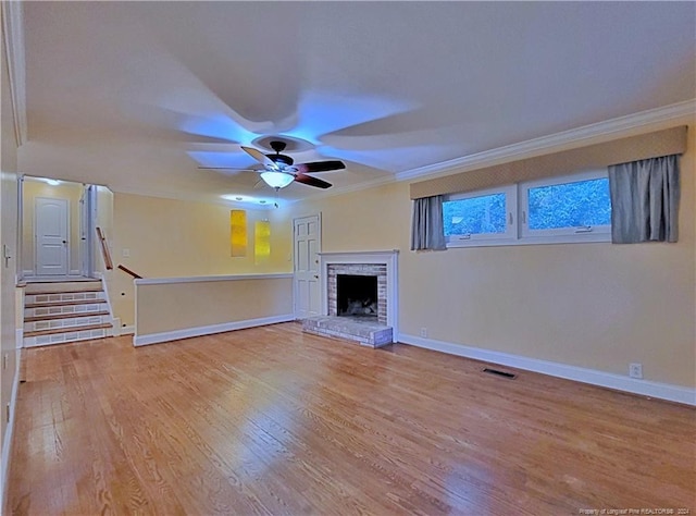 unfurnished living room featuring crown molding, a fireplace, ceiling fan, and hardwood / wood-style flooring