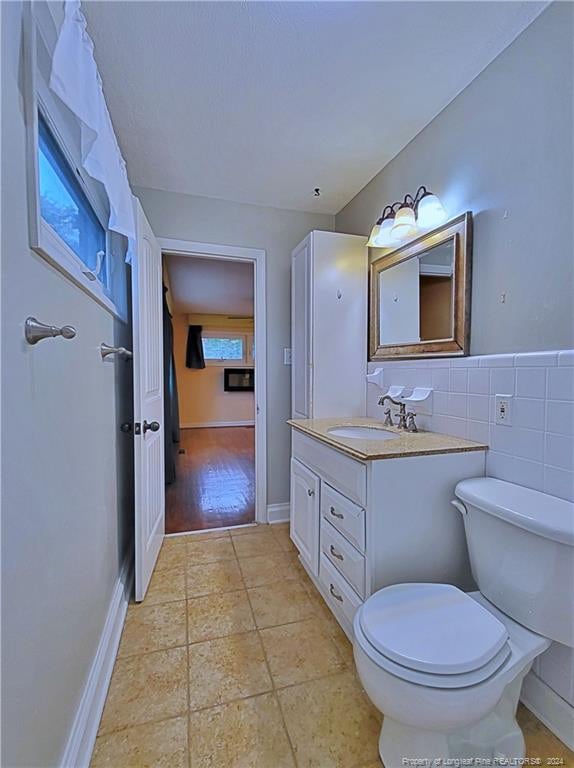 bathroom with hardwood / wood-style flooring, vanity, and toilet