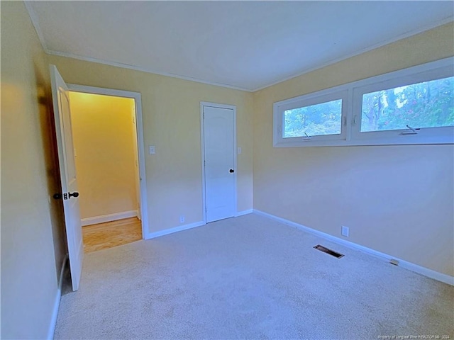 unfurnished bedroom with carpet flooring, a closet, and ornamental molding