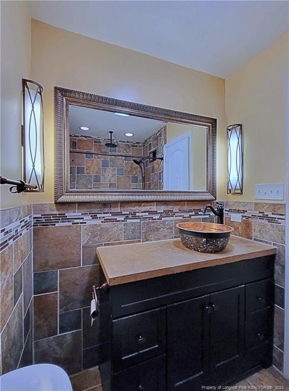 bathroom featuring vanity, tile walls, and tiled shower