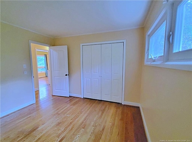 unfurnished bedroom with light hardwood / wood-style floors and a closet