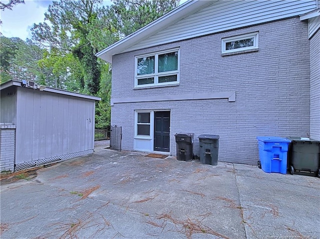 back of property featuring a patio area and a storage unit