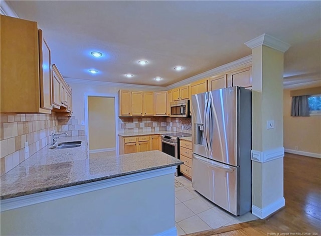 2519 Mirror Lake Dr, Fayetteville, NC 28303 - kitchen featuring a sink, a peninsula, ornamental molding, baseboards, and appliances with stainless steel finishes