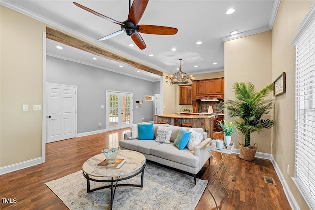 living room featuring ceiling fan with notable chandelier, french doors, ornamental molding, and dark hardwood / wood-style flooring