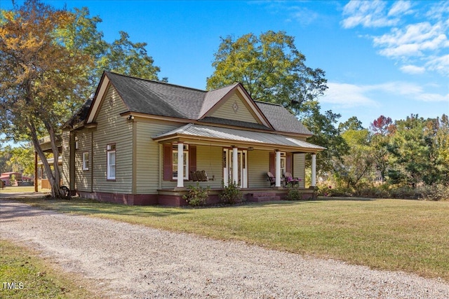 farmhouse-style home featuring a porch and a front yard